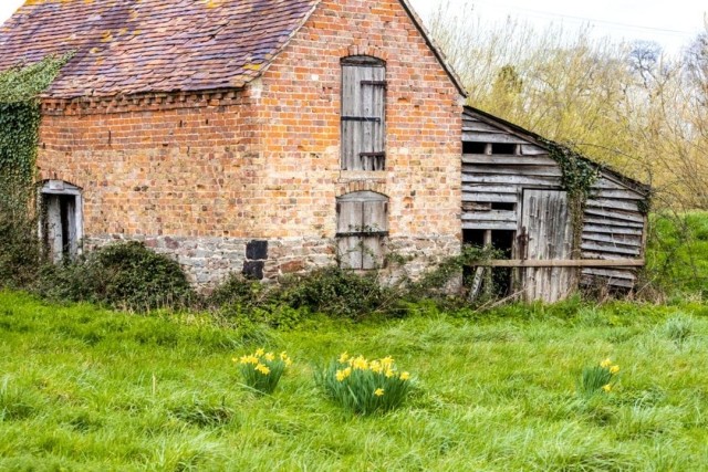 Image cover for the article: Construction site of a two-story house extension with scaffolding, showing a completed modern section with large glass doors and an unfinished brick structure, illustrating phases in residential development.